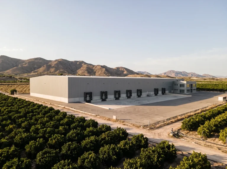 Almacén agrícola de manipulado con muelles de carga entre campos de cítricos en la Región de Murcia